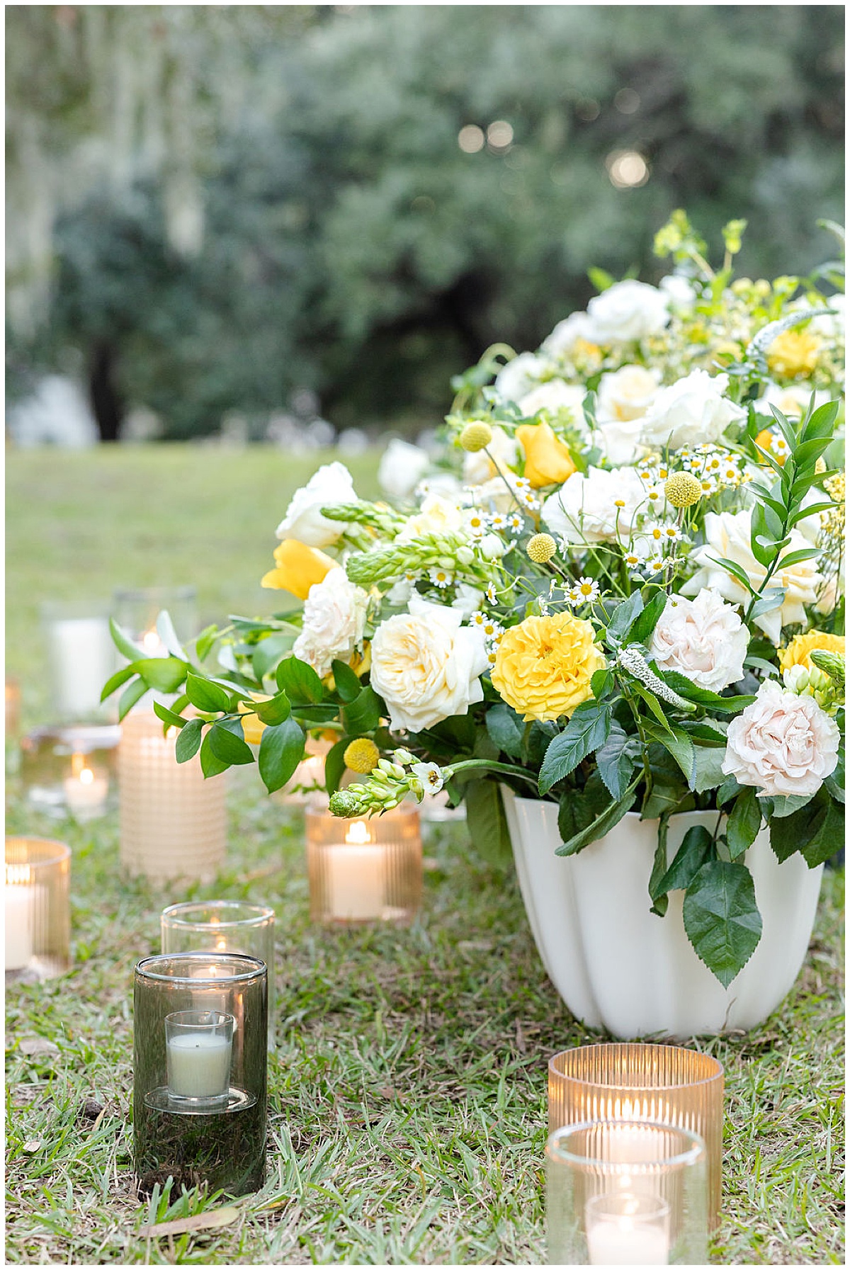 Yellow and White floral arrangement surrounded by candles for a Charleston Proposal at Hampton Park.