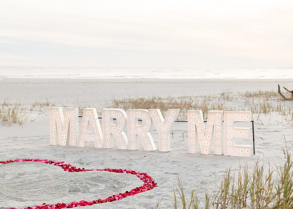 Folly Beach Proposal with Marry Me Letters at Sunset and red rose petals
